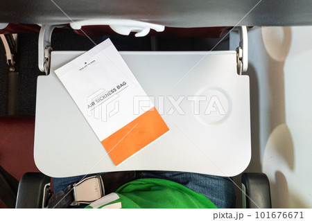 Air sickness paper bag on table inside airplane cabin 101676671