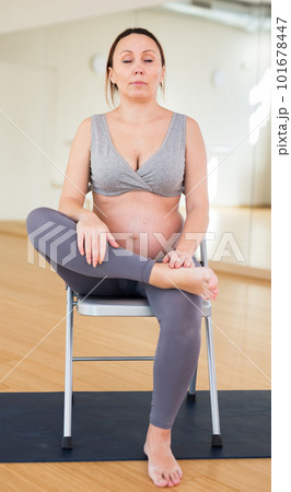 Pregnant woman is engaged in yoga. Chair Pigeon or Eka Pada Rajakapotasana 101678447