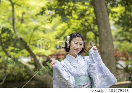 新緑の中を散策する着物の女性 101679158