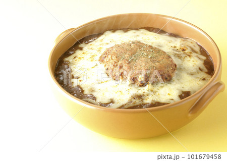 たっぷりのチーズとハンバーグが乗っている熱々焼きカレー 101679458