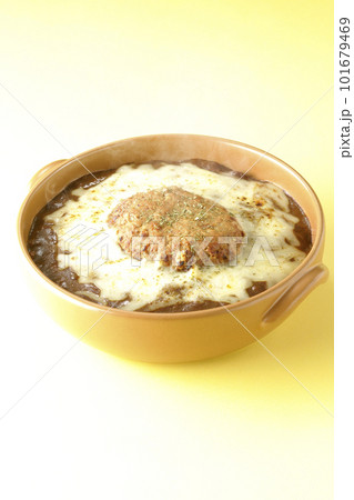 たっぷりのチーズとハンバーグが乗っている熱々焼きカレー 101679469