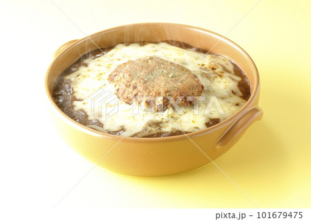 たっぷりのチーズとハンバーグが乗っている熱々焼きカレー 101679475
