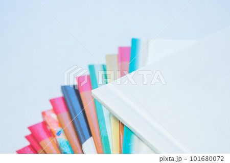 multi-colored spines of photo books close-up, partial blur 101680072