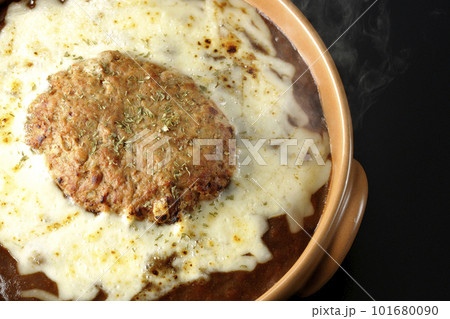 たっぷりのチーズとハンバーグが乗っている熱々焼きカレーを黒背景で俯瞰撮影 たっぷりのチーズとハンバーグが乗っている熱々焼きカレーを黒背景で俯瞰撮影 101680090