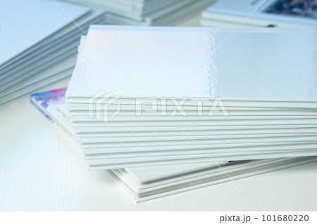 stacks of freshly printed photobooks with clean empty white covers on the table close-up 101680220