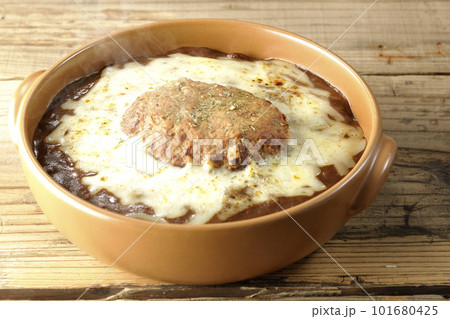 たっぷりのチーズとハンバーグが乗っている熱々焼きカレー たっぷりのチーズとハンバーグが乗っている熱々焼きカレー 101680425