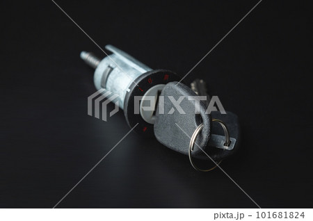 Ignition lock with a key made of black plastic on a black background in a photo studio, a spare part for car repair or for sale in a junkyard. Ignition lock with a key made of black plastic on a black background in a photo studio, a spare part for car repair or for sale in a junkyard. 101681824