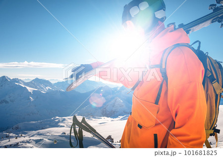 shot of a skier standing on top of a mountain with skis on his shoulder on a sunny winter day, sunlight, outdoor recreation, skiing, lifestyle, downhill sport concept shot of a skier standing on top of a mountain with skis on his shoulder on a sunny winter day, sunlight, outdoor recreation, skiing, lifestyle, downhill sport concept 101681825