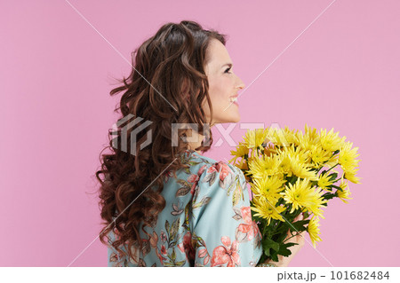 smiling young woman in floral dress on pink smiling young woman in floral dress on pink 101682484