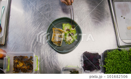 Chef puts walnuts and berries on top of dish 101682506