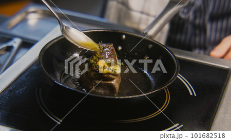 Male cook pours beef meat with oil Male cook pours beef meat with oil 101682518