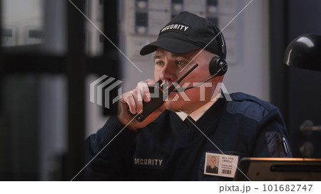 Busy security worker talks with coworker by walkie talkie 101682747