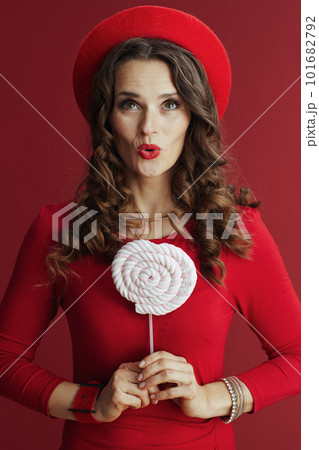 excited elegant woman in red dress and beret on red background 101682792