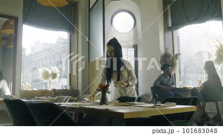 Waitress prepares restaurant with modern design Waitress prepares restaurant with modern design 101683048