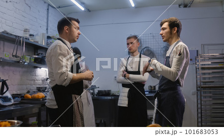 Adult chef stands with colleagues and discussing menu 101683053
