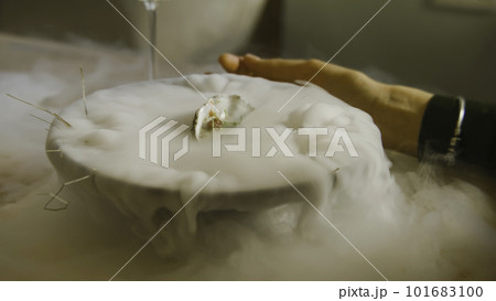 Pouring liquid in meal to make dry ice steam 101683100