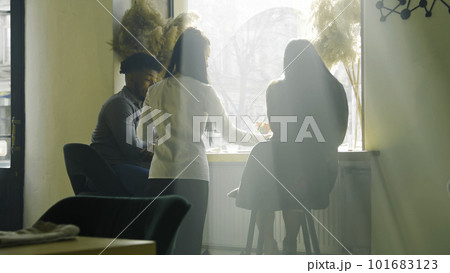 Couple sit near window, talk and drink wine Couple sit near window, talk and drink wine 101683123