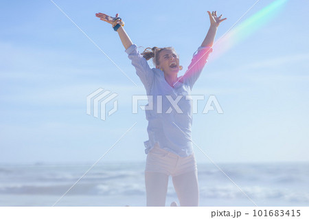 smiling elegant female at beach rejoicing and jumping smiling elegant female at beach rejoicing and jumping 101683415
