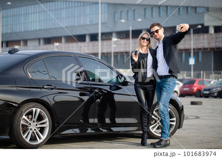 Beautiful young smiling couple holding a key of their new car. Beautiful young smiling couple holding a key of their new car. 101683974