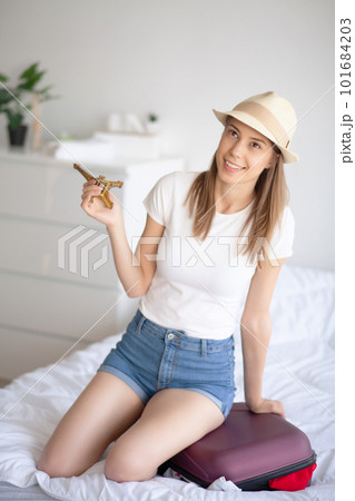Portrait of positive young woman with packed baggage and notes 101684203