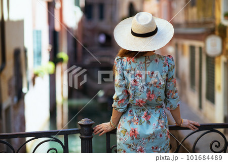 Seen from behind stylish traveller woman in floral dress Seen from behind stylish traveller woman in floral dress 101684489