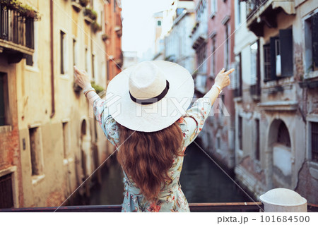 Seen from behind traveller woman in floral dress 101684500