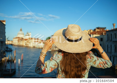 Seen from behind trendy woman in floral dress with hat Seen from behind trendy woman in floral dress with hat 101684504