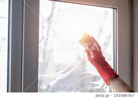 They cleans the window with a sponge with a cleaning agent. 101686567