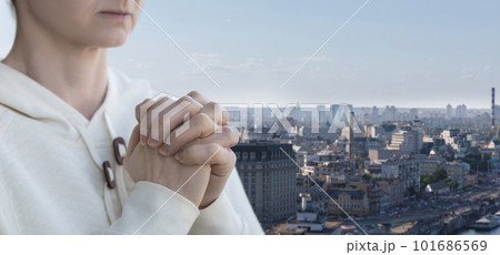 A prays against the backdrop of the city. 101686569