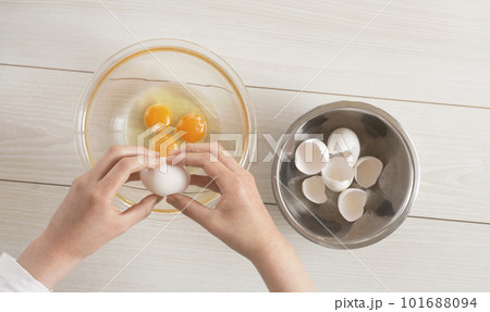 ボウルに生卵を割る女性 101688094