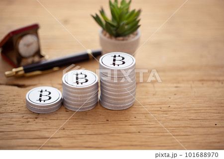 テーブルに積み上げられたお金（ビットコイン） 101688970