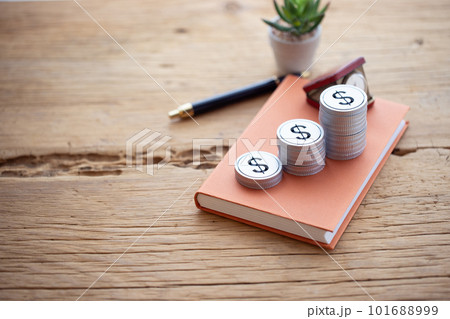 本の上に積み上げたお金（ドル） 101688999