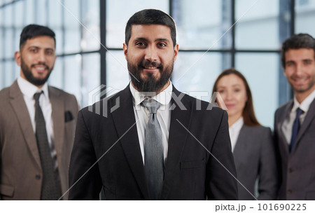 portrait shot of smiling business team of four standing and smiling at camera against a modern office background 101690225