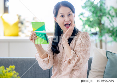 通帳を見て喜ぶ女性 通帳を見て喜ぶ女性 101690289