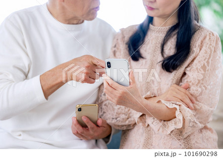 スマホを見るシニア夫婦 101690298