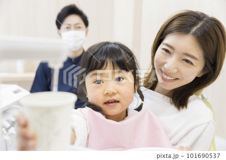歯医者でうがいをするお母さんに抱っこされた女の子 歯医者でうがいをするお母さんに抱っこされた女の子 101690537