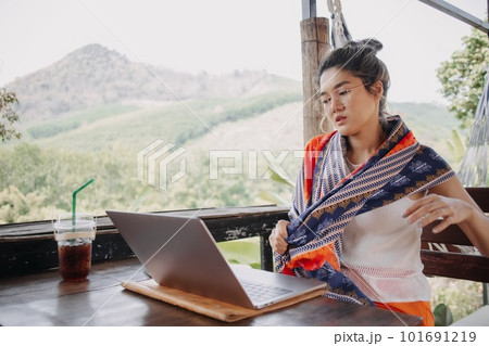 Tourist woman working online in the cafe while on traveling trip. 101691219
