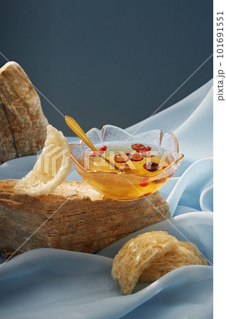 A bowl soup of bird nest distilled with jujube, next to is raw edible bird nest decorated on stone and blue soft fabric background. Advertising scene for natural island bird nest products A bowl soup of bird nest distilled with jujube, next to is raw edible bird nest decorated on stone and blue soft fabric background. Advertising scene for natural island bird nest products 101691551