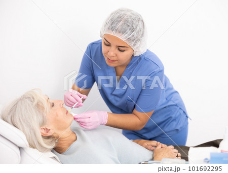Old woman having mesotherapy procedure on her face 101692295