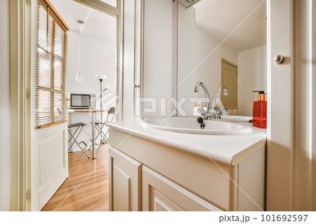 a bathroom with wood flooring and white walls, along with a large mirror in the corner of the room a bathroom with wood flooring and white walls, along with a large mirror in the corner of the room 101692597