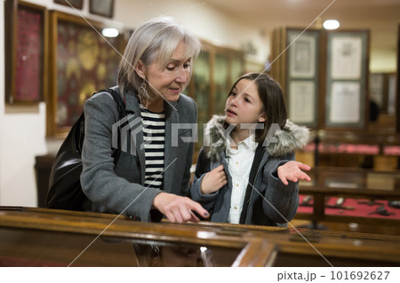 Senior woman and tween girl observing arts and crafts in museum 101692627