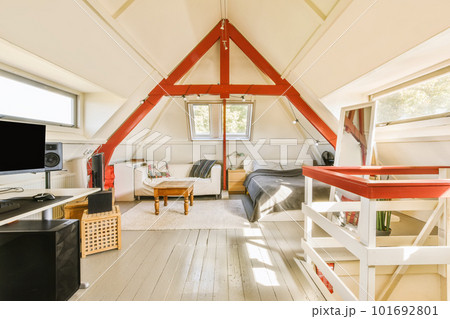 a living room with wood flooring and an attic - style loft that has been used as a home office 101692801