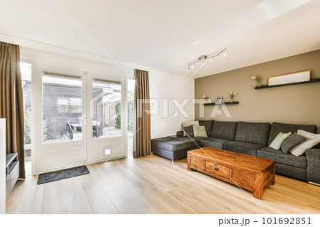 a living room with wood flooring and sliding glass doors that open onto the patio to let in natural light a living room with wood flooring and sliding glass doors that open onto the patio to let in natural light 101692851