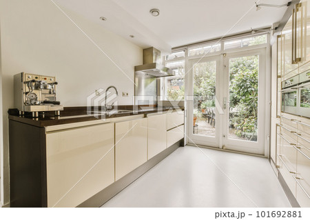 a modern kitchen with white cabinets and black counter tops in an open doord area that leads to the patio 101692881