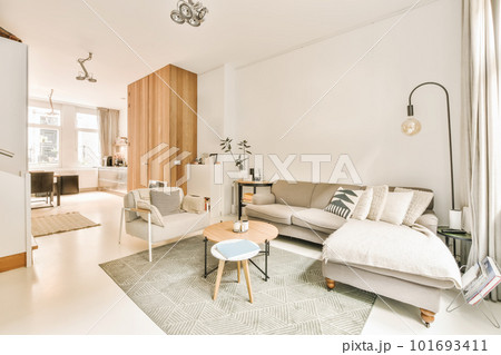 a living room with white walls and wood paneled panels on the wall behind it is a couch, coffee table, two chairs a living room with white walls and wood paneled panels on the wall behind it is a couch, coffee table, two chairs 101693411
