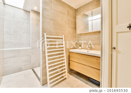 a modern bathroom with beige tile walls and white tiles on the wall, there is a towel rack next to the sink a modern bathroom with beige tile walls and white tiles on the wall, there is a towel rack next to the sink 101693530