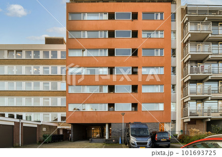 an apartment building with cars parked on the street next to it and two buildings in the background are bricked an apartment building with cars parked on the street next to it and two buildings in the background are bricked 101693725