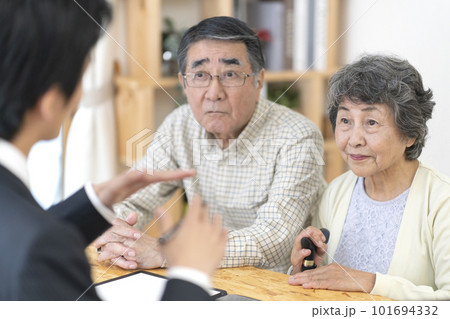訪問営業と話しをするシニア夫婦 101694332