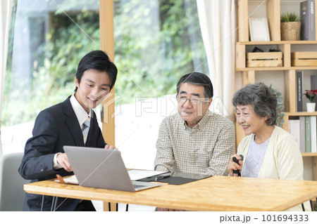 訪問営業と話しをするシニア夫婦 101694333