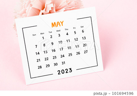 Close up the May 2023 Monthly desk calendar with dried flower on pink background. 101694596
